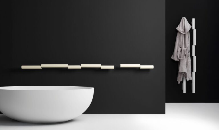 Radiateur Pypeline crème posé à l'horizontale sur un mur noir, version verticale blanche avec peignoir, baignoire blanche