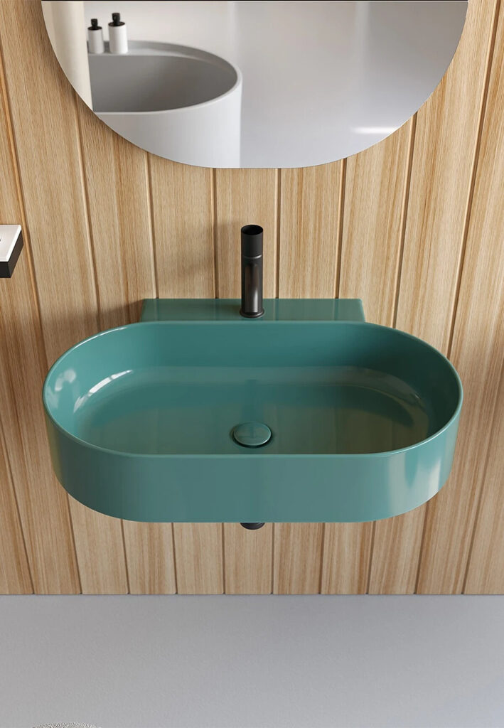 Vasque ovale turquoise suspendue avec robinet noir devant un mur en lattes de bois