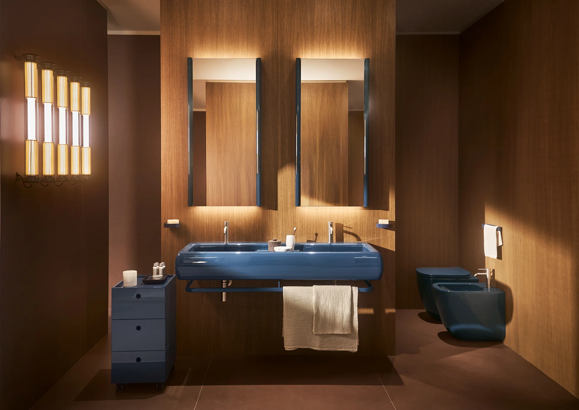 Lavabos ceramica cielo Teseo : double vasque suspendue bleue avec étagère céramique devant un mur en bois éclairé