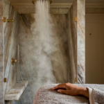 Douche ouverte en marbre baignée de vapeur dans une suite parentale haussmannienne, inspirée de l'univers Gessi Haute Culture